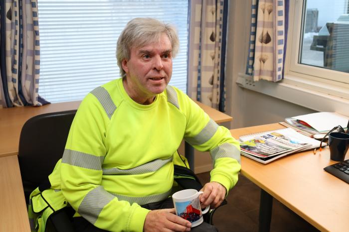 JOBBER 20 PROSENT: I dag jobber Jan Inge 20 prosent hos Rivenes som fagansvarlig. Her sitter han på kontoret og har fått laget en egen kopp med sin favorittbil, Anleggs Giganten. Foto: Elisabeth Nodland