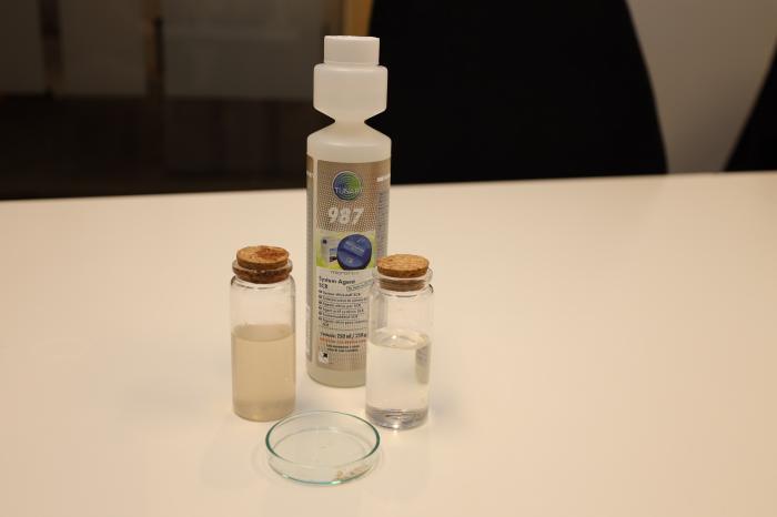 EFFEKTIVT: I glasset til venstre er det Adblue tatt fra en forurenset tank, men glasset til høyre inneholder Adblue tilsatt rensemiddel. Foran i petriskålen ser vi klassiske saltkrystaller som kan oppstå. Disse vil løses opp og forsvinne ved bruk av 987 – AdBlue-tilsetning. Foto: Elisabeth Nodland