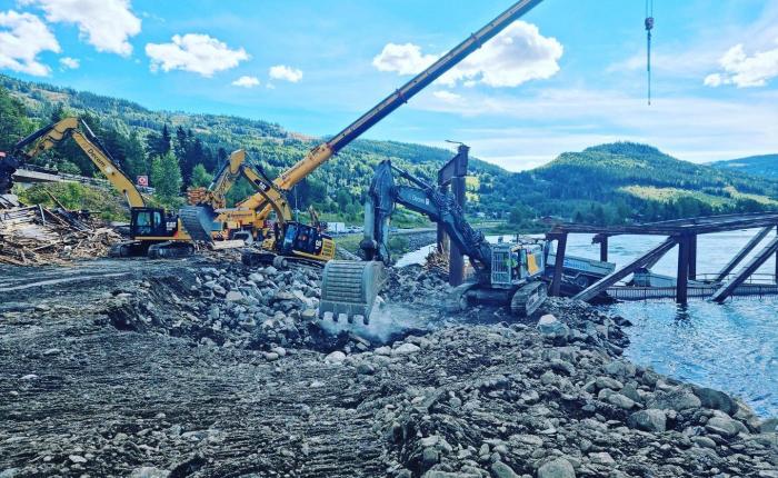 FORARBEID: Det var mye forarbeid som måtte gjøres for å få bilen trygt av brua. Området rundt brua ser ut som et anleggsområde. Foto: Gudbrandsdal Bilberging