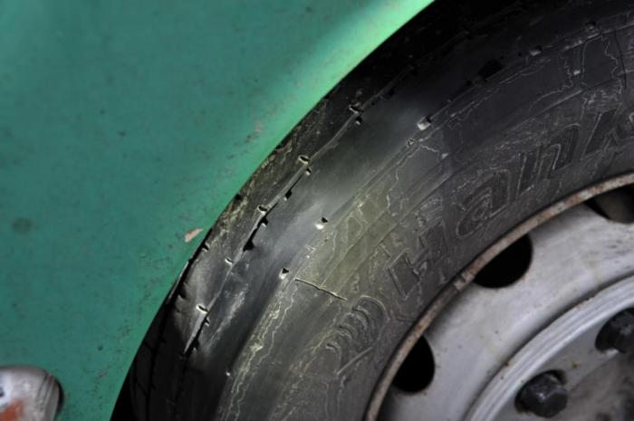 BLANKSLITTE: Uten kjetting og med blankslitte dekk var denne bilen på vei til en bedrift i Buskerud. I tillegg var det tuklet med fartsskriveren og det var brudd på kjøre- og hviletidsbestemmelsene. Føreren hadde heller ikke gyldig førerattest. (Foto: Jan Harry Svendsen)